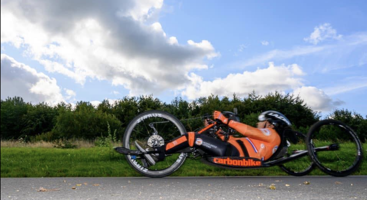 Carmen de personal trainer voor mensen met een beperking, terwijl ze traint met haar handbike in de buitenlucht.